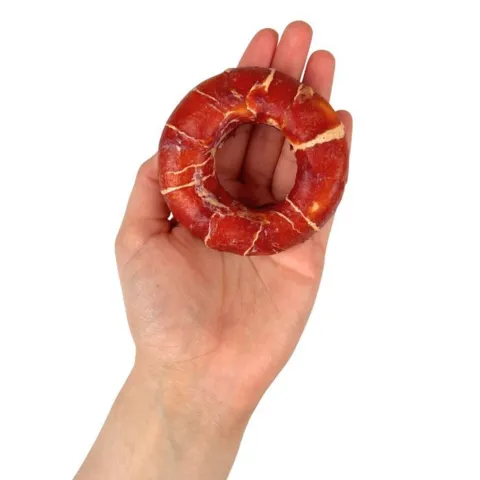 Råhud donut med and og fisk 7 cm hundegodbid vist i hånden
