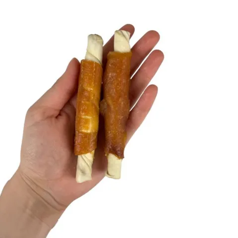 Faunakram filled rawhide roll med kylling vist i hånd
