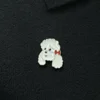 Broche med fint motiv af hvid krøllet hund