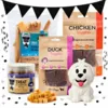 Black November pakketilbud med Mini Bits med fisk, Nuggets med and og kylling, Buffalo Chips og Ollipet Ollie latexlegetøj, omgivet af sorte flag og confetti