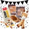 Hyggepakke til hunde med Dogman tyggefletninger, to poser Softies, kalveklov og Sally-girafbamse, vist med Black November-flagguirlande